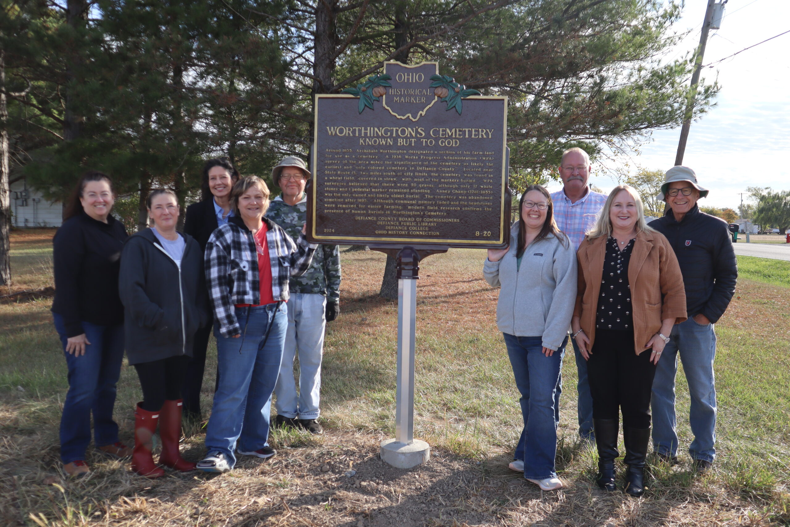 A group of community partners standing next to teh newly installed historic marker at Worthington Cemetery