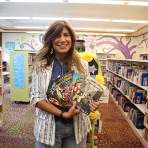 A photo of author Christina Trevino holding her books at Defiance Public Library